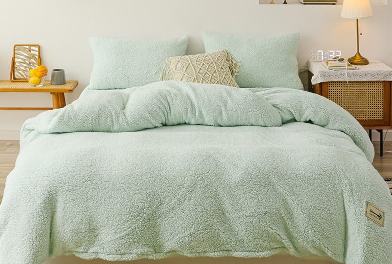 Parure de lit vert clair effet fourrure. Bonne qualité, confortable et à la mode sur un lit dans une maison