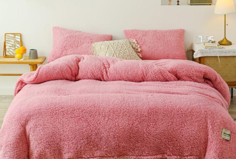 Parure de lit rose saumon effet fourrure. Bonne qualité, confortable et à la mode sur un lit dans une maison