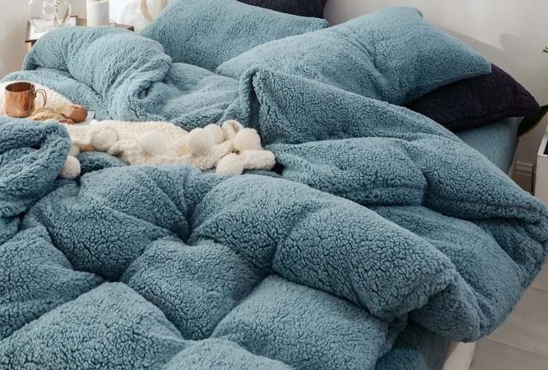 Parure de lit bleu canard effet fourrure. Bonne qualité, confortable et à la mode sur un lit dans une maison