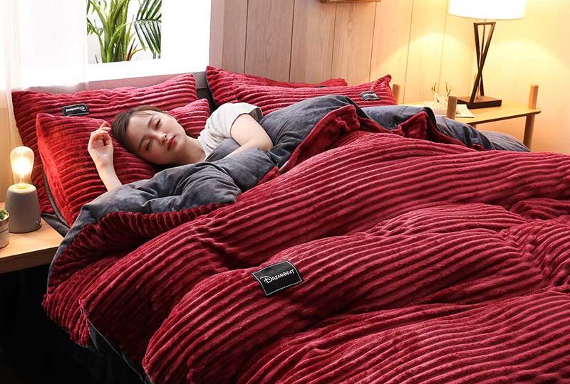 Parure de lit unie rouge en flanelle. Bonne qualité, confortable et à la mode sur un lit dans une maison