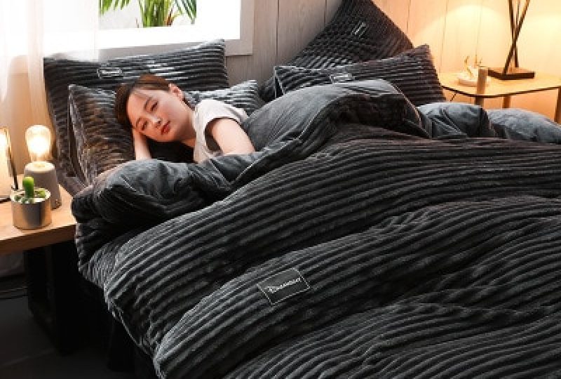 Parure de lit unie noir en flanelle. Bonne qualité, confortable et à la mode sur un lit dans une maison
