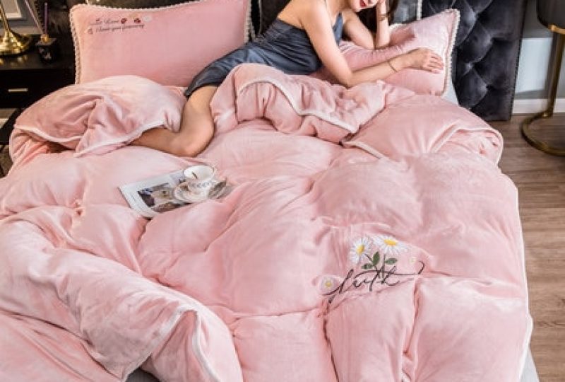 Parure de lit rose avec contour blanc. Bonne qualité, confortable et à la mode sur un lit dans une maison