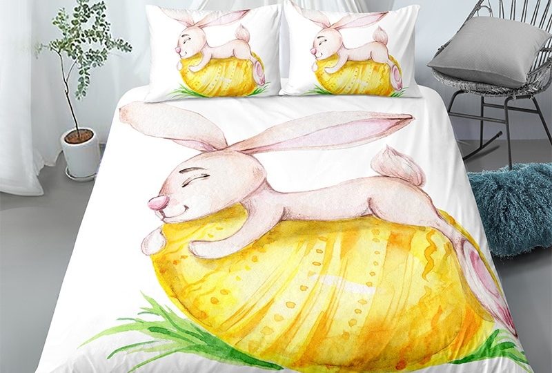 Parure de lit blanche motif lapin câlinant un œuf de pâque. Bonne qualité, confortable et à la mode sur un lit dans une maison
