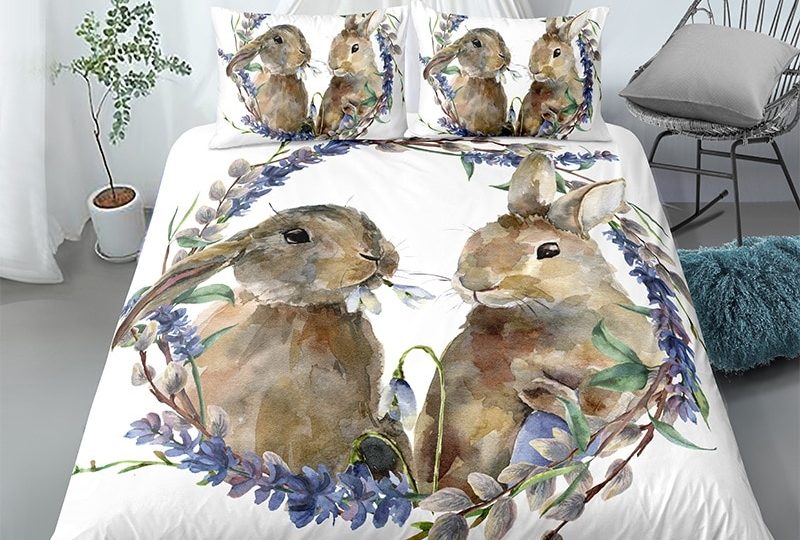 Parure de lit blanche motif couple de lapins. Bonne qualité, confortable et à la mode sur un lit dans une maison avec une chaise
