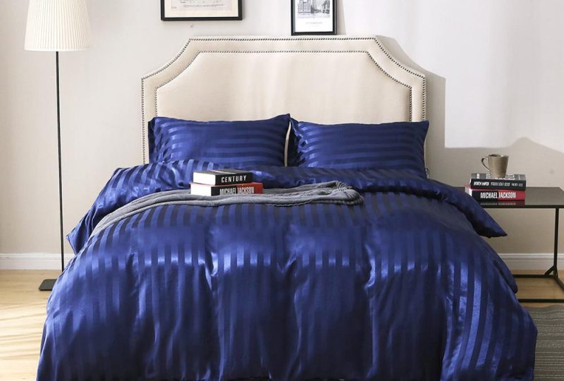 Parure de lit bleu royal rayée ton sur ton. Bonne qualité, confortable et à la mode sur un lit dans une maison