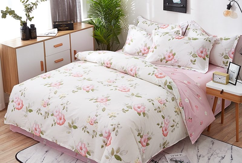 Parure de lit blanche en coton à motif floral. Bonne qualité, confortable et à la mode sur un lit dans une maison
