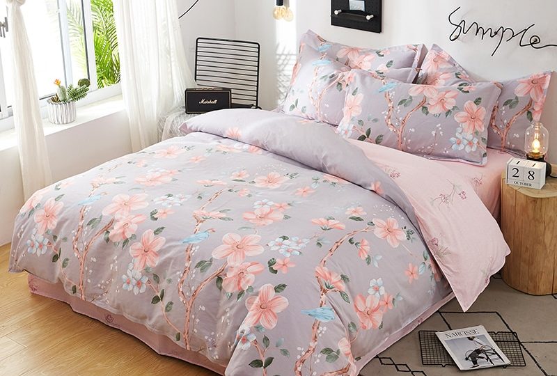Parure de lit grise en coton motif floral. Bonne qualité, confortable et à la mode sur un lit dans une maison