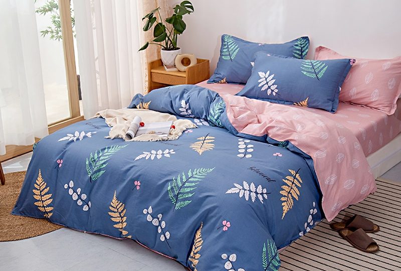 Parure de lit bleue motif feuilles. Bonne qualité, confortable et à la mode sur un lit dans une maison