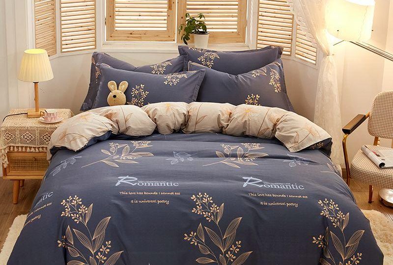 Parure de lit bleu profond inscription Romantic. Bonne qualité, confortable et à la mode sur un lit dans une maison