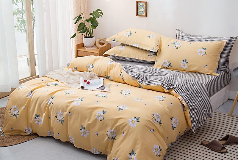 Parure de lit jaune sable en coton avec imprimé fleuri. Bonne qualité, confortable et à la mode sur un lit dans une maison
