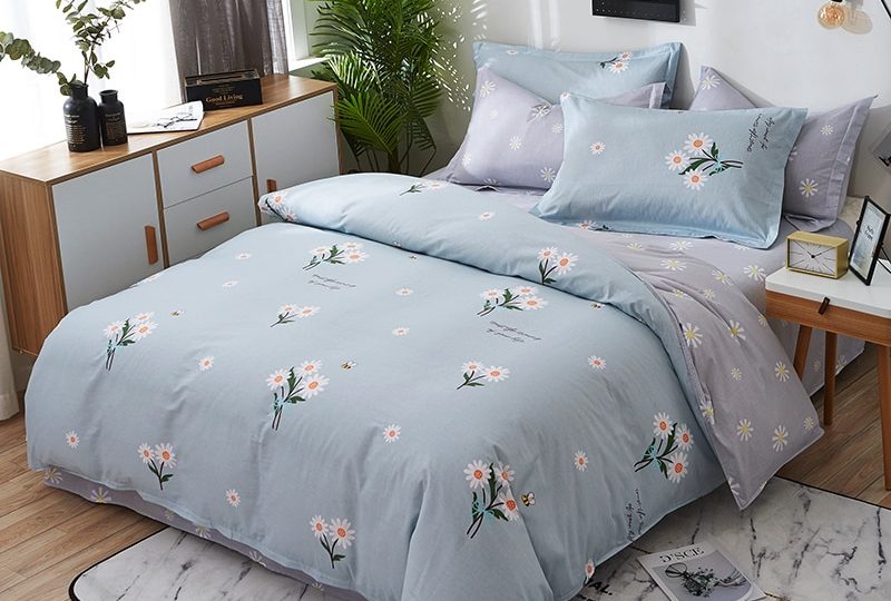 Parure de lit bleu-gris en coton à motif floral. Bonne qualité, confortable et à la mode sur un lit dans une maison