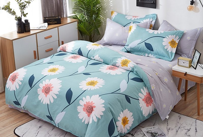 Parure de lit bleue avec imprimé fleuri blanc. Bonne qualité, confortable et à la mode sur un lit dans une maison