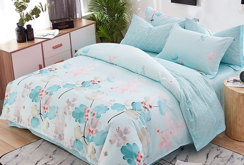 Parure de lit fleurie bleu clair en coton. Bonne qualité, confortable et à la mode sur un lit dans une maison