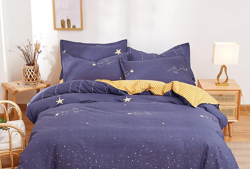 Parure de lit bleu nuit avec imprimé étoile en coton. Bonne qualité, confortable et à la mode sur un lit dans une maison