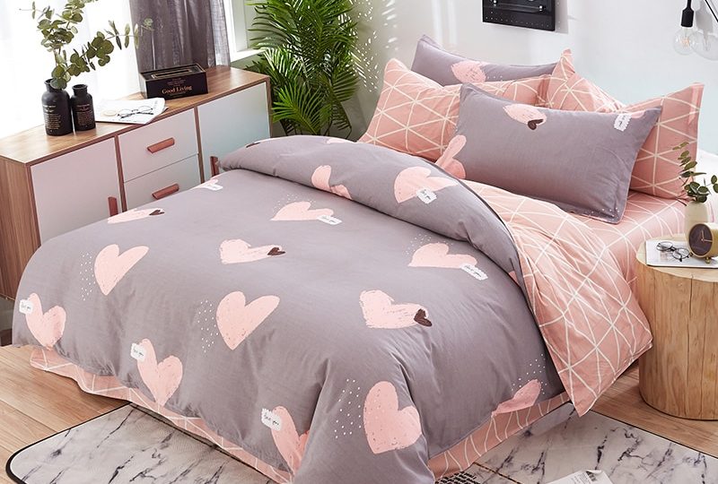 Parure de lit grise à motif cœur en coton. Bonne qualité, confortable et à la mode sur un lit dans une maison