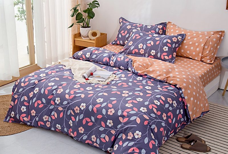 Parure de lit violette en coton avec imprimé fleuri. Bonne qualité, confortable et à la mode sur un lit dans une maison