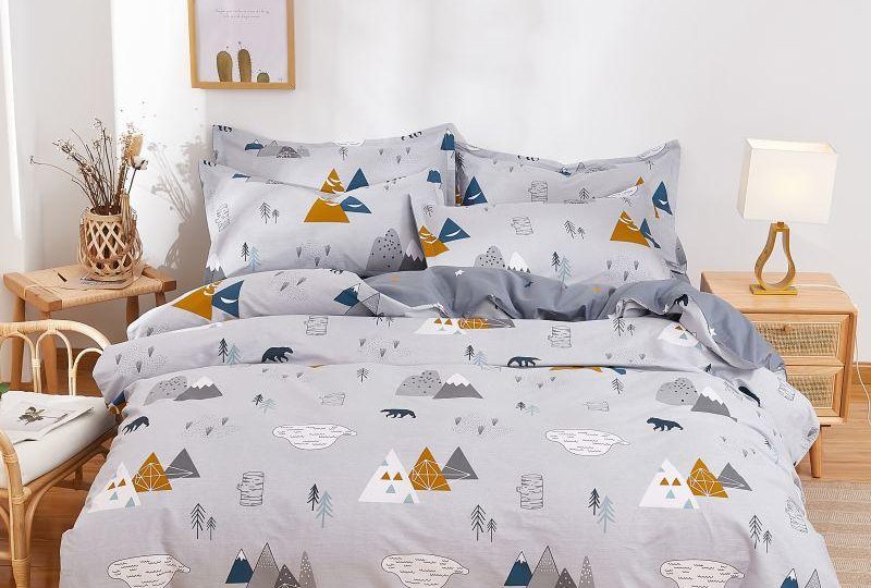 Parure de lit grise en coton à motif montagne. Bonne qualité, confortable et à la mode sur un lit dans une maison