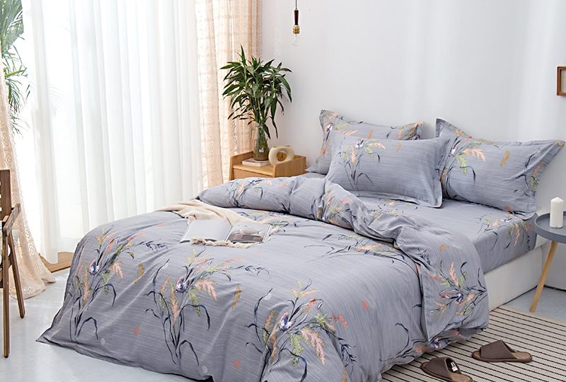 Parure de lit grise à motif floral en coton. Bonne qualité, confortable et à la mode sur un lit dans une maison