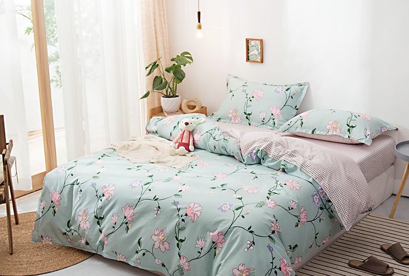 Parure de lit vert-gris en coton à motif floral. Bonne qualité, confortable et à la mode sur un lit dans une maison