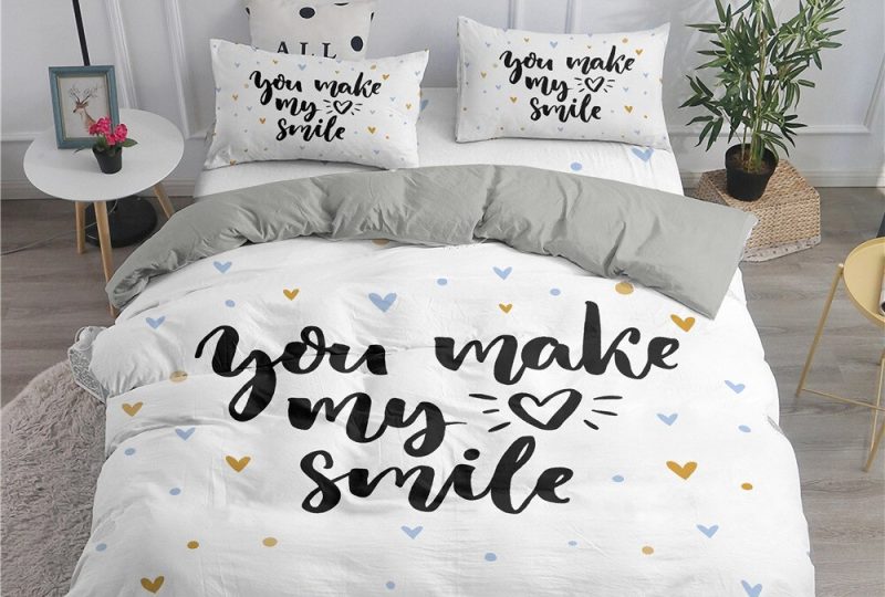 Parure de lit blanche inscription « You make my heart smile ». Bonne qualité, confortabke et à la mode sur un lit dans une maison