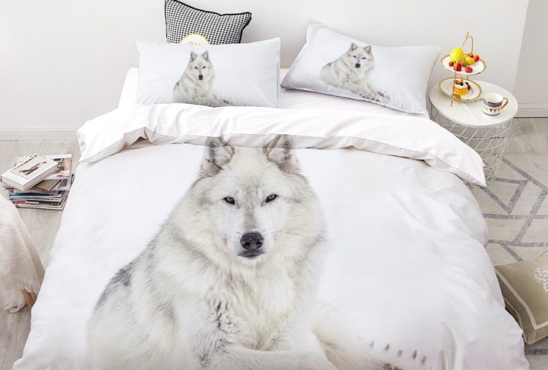 Parure de lit blanche à motif loup blanc assis. Bonne qualité, confortable et à la mode sur un lit dans une maison