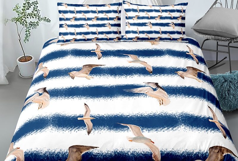 Parure de lit à rayures bleu et blanc à motif oiseaux. Bonne qualité, confortable et à la mode sur un lit dans une maison
