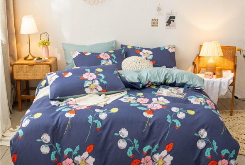 Parure de lit bleue à motif floral. Bonne qualité, confortable et à la mode sur un lit dans une maison