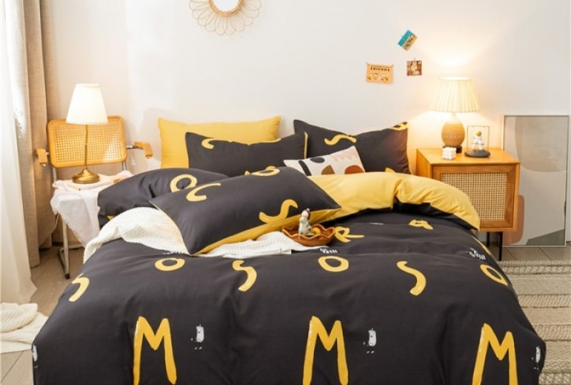 Parure de lit marron avec imprimés lettres jaunes. Bonne qualité, confortable et à la mode sur un lit dans une maison