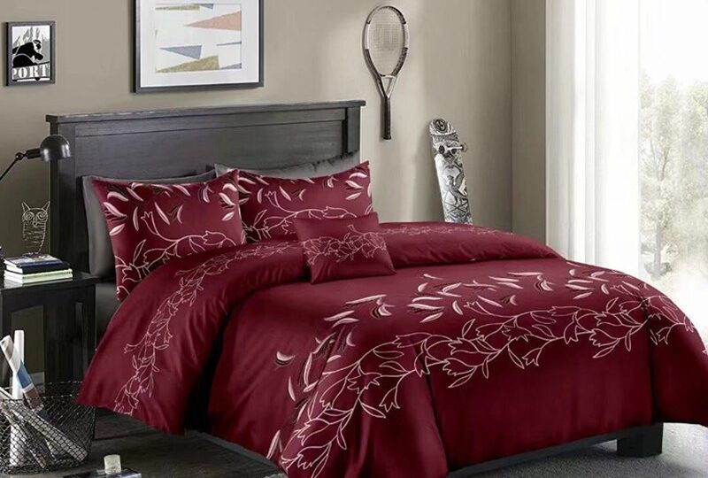 Parure de lit bourgogne à motif floral blanc. Bonne qualité, confortable et à la mode sur un lit dans une maison
