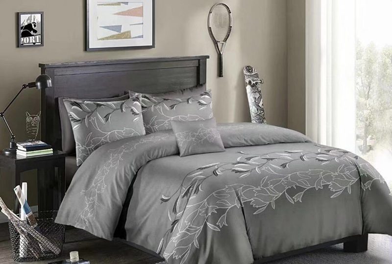 Parure de lit gris clair à motif floral blanc. Bonne qualité, confortable et à la mode sur un lit dans une maison