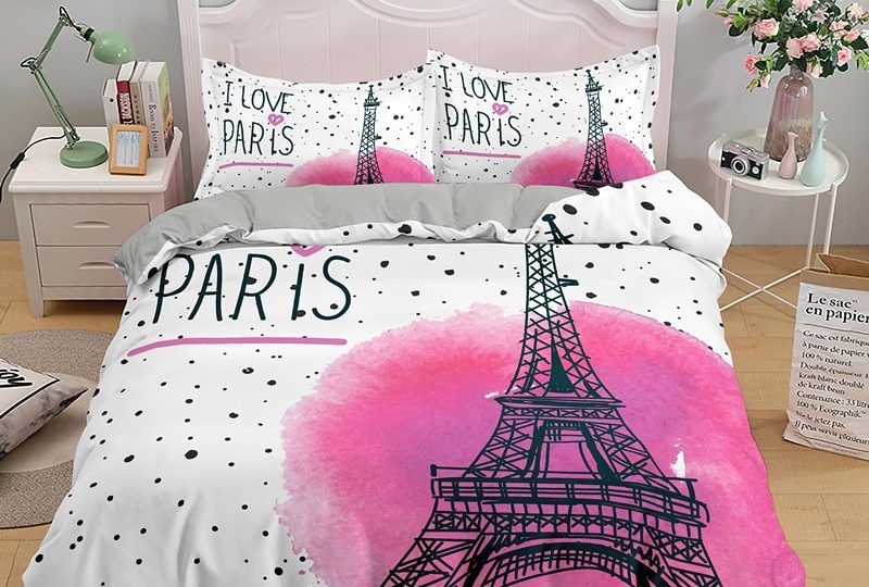 Parure de lit blanche avec imprimé Tour Eiffel. Bonne qualité, confortable et à la mode sur un lit dans une maison