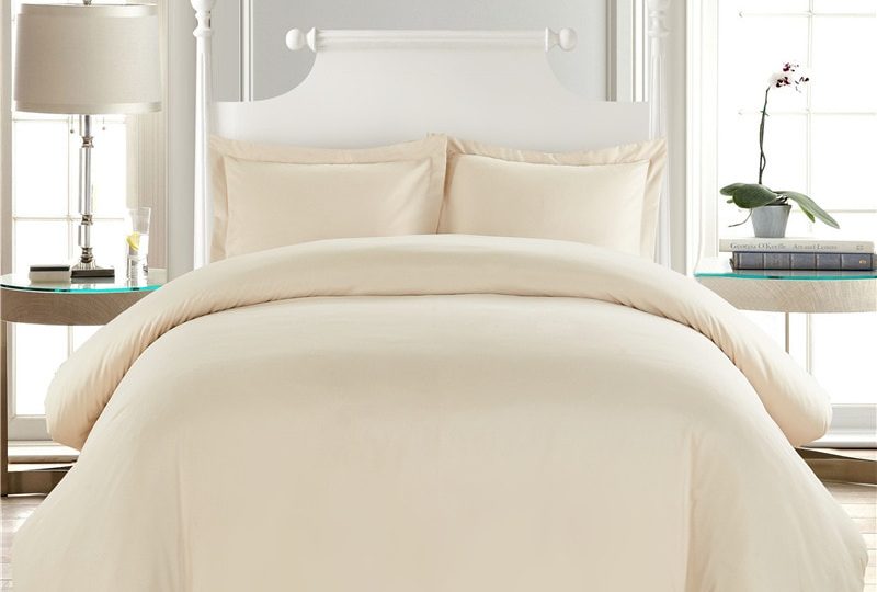 Parure de lit unie blanc cassé confortable. Bonne qualité, confortable et à la mode sur un lit dans une maison