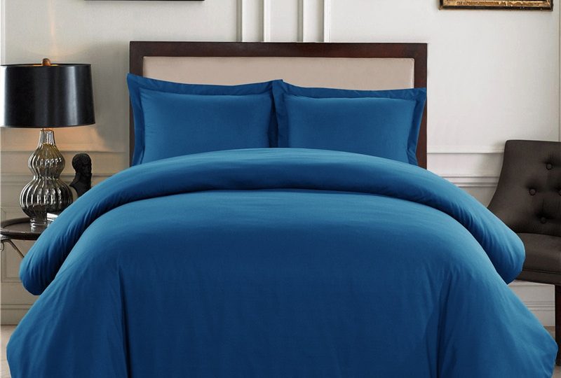 Parure de lit unie bleue style élégant. Bonne qualité, confortable et à la mode sur un lit dans une maison