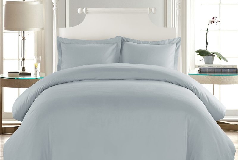 Parure de lit unie gris clair confortable. Bonne qualité, confortable et à la mode sur un lit dans une maison