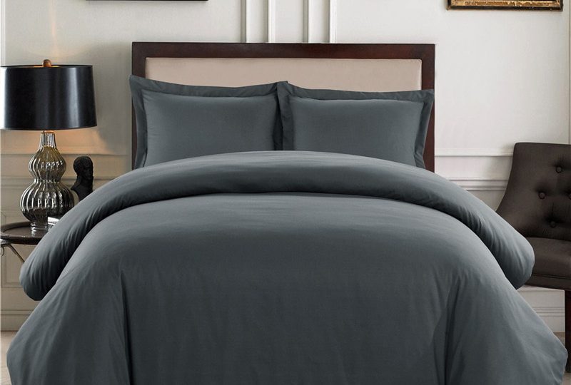 Parure de lit unie gris foncé confortable. Bonne qualité, confortable et à la mode sur un lit dans une maison