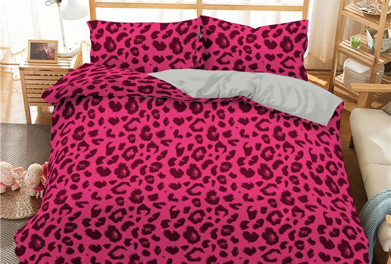 Parure de lit rose avec imprimé léopard. Bonne qualité, confortable et à la mode sur un lit dans une maison