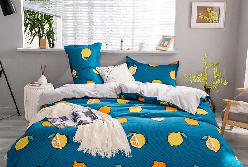 Parure de lit bleue avec motif citron. Bonne qualité, confortable et à la mode sur un lit dans une maison