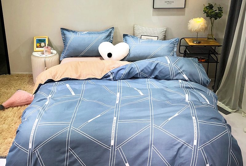 Parure de lit bleu royal à motifs géométriques. Bonne qualité, confortable et à la mode sur un lit dans une maison