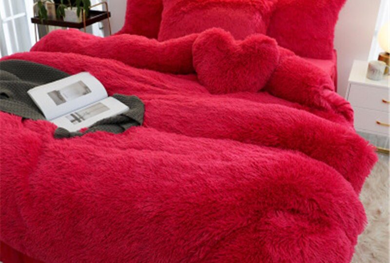 Parure de lit rouge cerise effet fourrure. Bonne qualité, confortable et à la mode sur un lit dans une maison