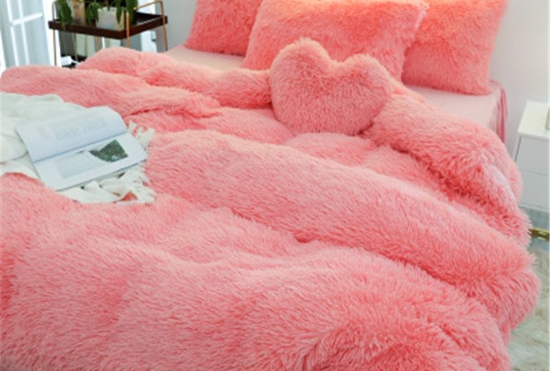 Parure de lit unie rose effet fourrure. Bonne qualité, confortable et à la mode sur un lit dans une maison