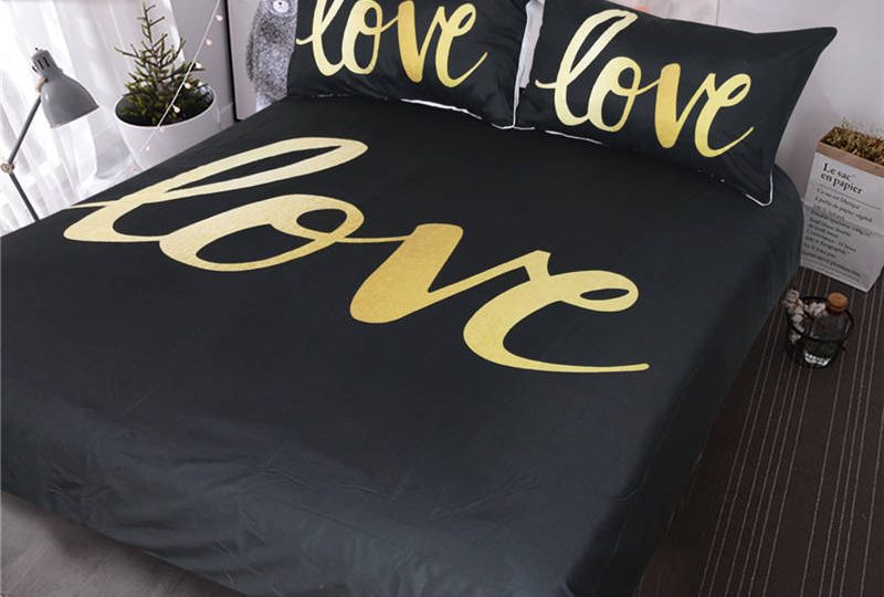 Parure de lit noire avec inscription « Love ». Bonne qualité, confortable et à la mode sur un lit dans une maison