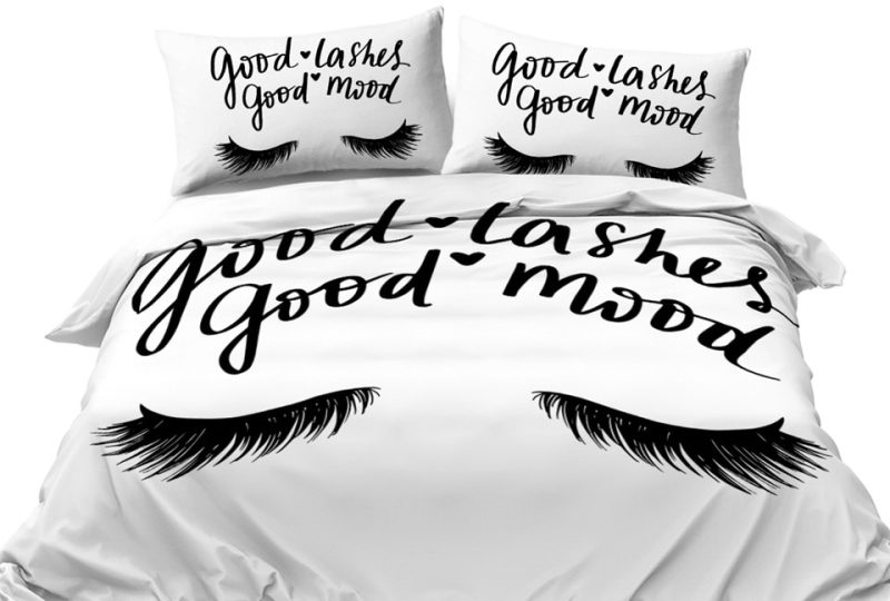 Parure de lit motif cils avec inscription « Good lashes, good mood ». Bonne qualité, confortable et à la mode sur un lit dans une maison
