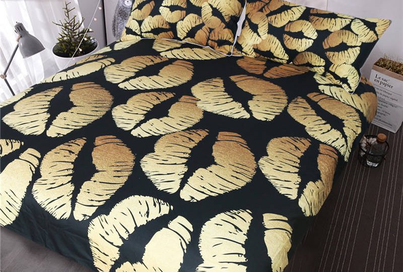 Parure de lit noire à motif lèvres dorées. Bonne qualité, confortable et à la mode sur un lit dans une maison