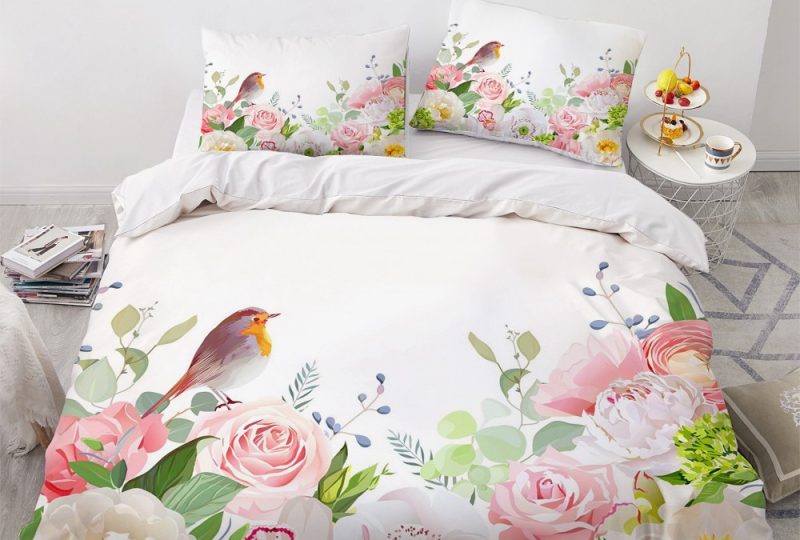 Parure de lit blanche à motifs fleurs et oiseau. Bonne qualité, confortable et à la mode sur un lit dans une maison