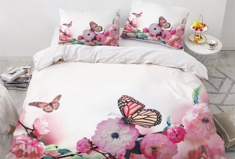 Parure de lit blanche à motif papillons sur roses sauvages. Bonne qualité, confortable et à la mode sur un lit dans une maison