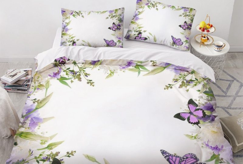 Parure de lit blanche bordée de fleurs et papillons. Bonne qualité, confortable et à la mode sur un lit dans une maison