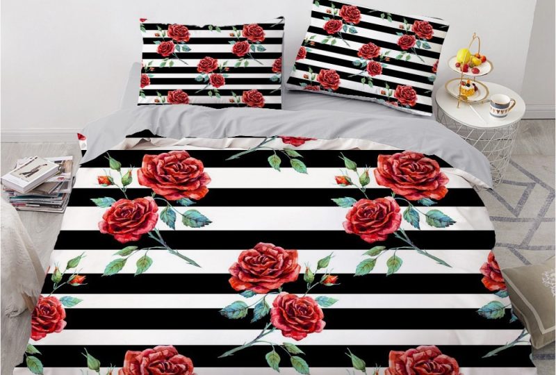 Parure de lit rayée noir et blanc à motif roses rouges. Bonne qualité, confortable et à la mode sur un lit dans une maison