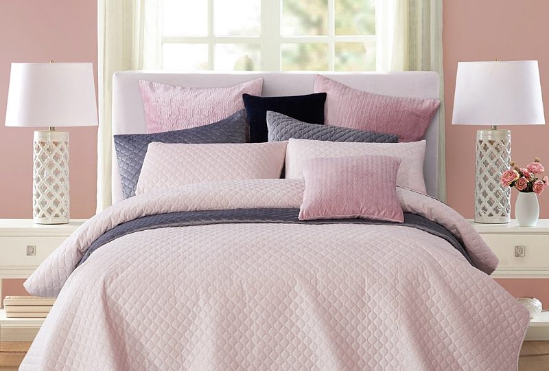 Parure de lit rose à motifs géométriques en relief. Bonne qualité, confortable et à la mode sur un lit dans une maison