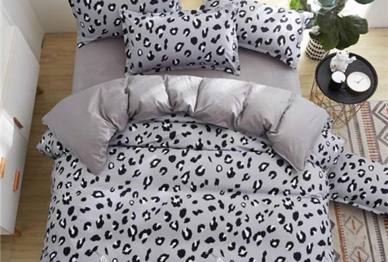 Parure de lit grise imprimé léopard. Bonne qualité, confortable et à la mode sur un lit dans une maison