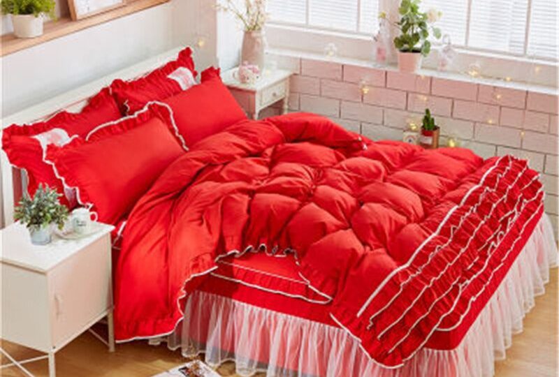 Parure de lit rouge à dentelle. Bonne qualité, confortable et à la mode sur un lit dans une maison